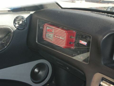 1998 Ford Crown Victoria - red MSD ignition control box mounted behind clear glove-box panel in a custom dashboard with a door speaker.