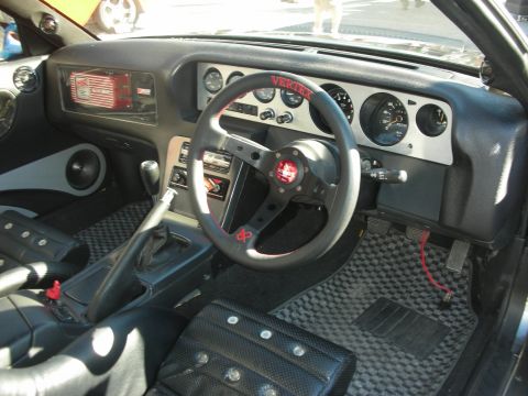 1998 Ford Crown Victoria - right-hand-drive custom interior with a racing steering wheel, aftermarket gauges and checkered carbon-look trim.