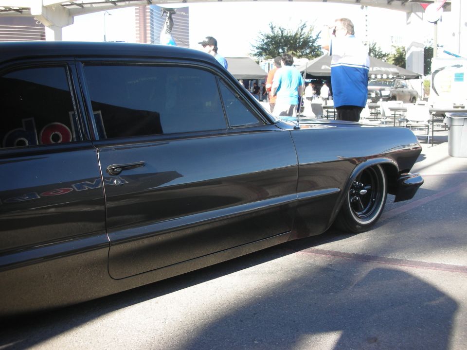 Side profile of a lowered black classic two-door coupe with black steel wheels