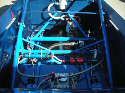 1998 Ford Crown Victoria - Looking down into a blue tube-frame race chassis with braided lines, fittings and an inspection plate.
