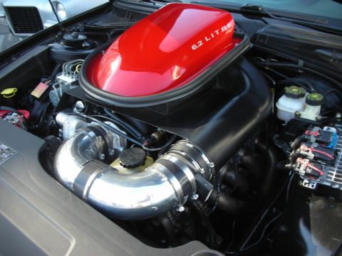 1998 Ford Crown Victoria - modern V8 engine bay topped with a red 6.2 LITRE air scoop and polished aluminum intake piping.