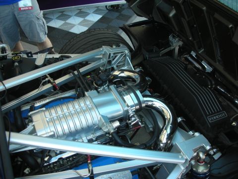 1998 Ford Crown Victoria - mid-mounted supercharged engine with polished blower seen through the rear hatch of a blue car.