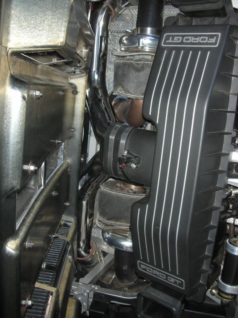 1998 Ford Crown Victoria - Close-up of a Ford GT engine bay with FORD GT-branded covers, chrome exhaust piping and an air filter.