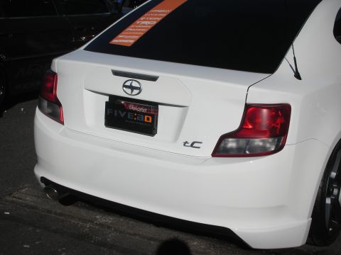 1998 Ford Crown Victoria - Rear view of a lowered white Scion tC coupe showing its tC badge, Scion logo and dealer plate frame.