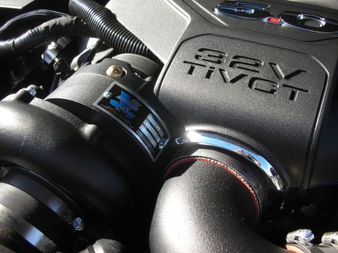 1998 Ford Crown Victoria - Close-up of a black 32V Ti-VCT engine cover with a chrome charge pipe and red-trimmed coupler.