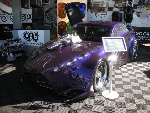 1998 Ford Crown Victoria - deep-purple custom coupe with an exposed supercharger displayed beside an info placard at a show.