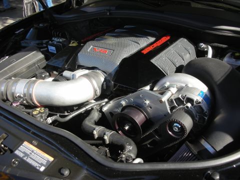 1998 Ford Crown Victoria - engine bay showing a belt-driven supercharger mounted to a V8 with finned cast covers and polished intake piping.