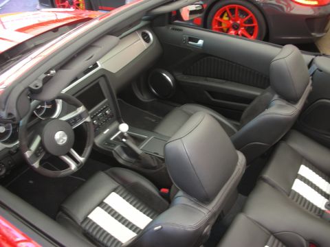 1998 Ford Crown Victoria - Interior of a Ford Mustang convertible showing black leather seats with white stripes, console shifter and pony-badge wheel.