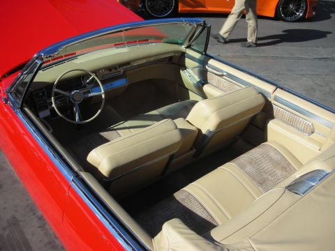 1998 Ford Crown Victoria - Top-down view of a red classic convertible's tan leather interior with bench seats and a chrome-trimmed dashboard.