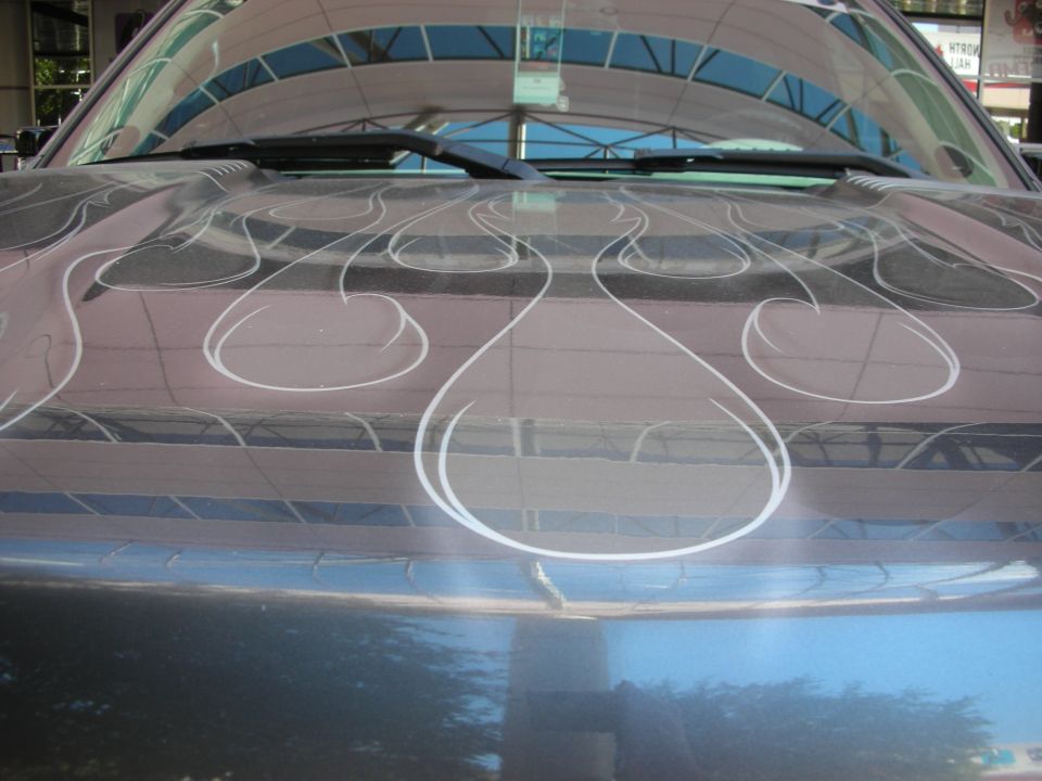 Close-up of pinstriped airbrushed flame paint on a car body panel
