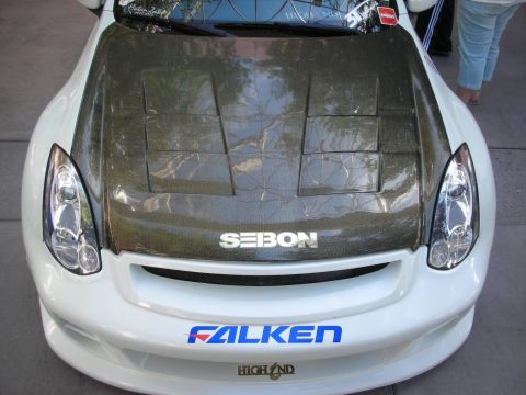1998 Ford Crown Victoria - Front view of a white sports coupe fitted with a vented carbon-fiber Seibon hood and a blue Falken windshield banner.