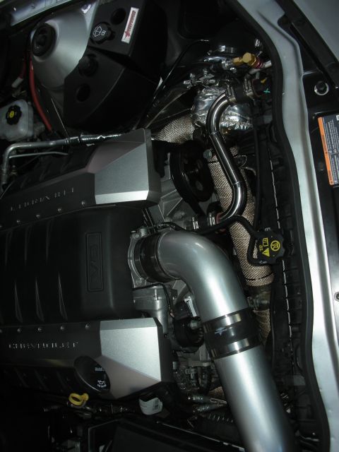 1998 Ford Crown Victoria - Engine-bay close-up of a V8 with cast intake, turbocharger and large silver charge piping in a modern car.