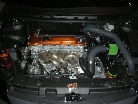 1998 Ford Crown Victoria - Engine-bay view showing a transverse engine with orange valve cover, polished race header and a green cone filter.