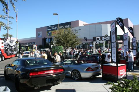 1998 Ford Crown Victoria - crowded outdoor show plaza with a black Dodge Challenger, silver convertible and DUB banners by a Giovanna sign.