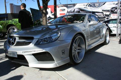 1998 Ford Crown Victoria - Silver widebody Mercedes-Benz SL with Forgiato.com decals and large alloy wheels shown front three-quarter at a car show.