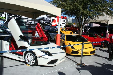 1998 Ford Crown Victoria - A white Lamborghini with its doors open is displayed next to a yellow sports car and a red Ferrari.