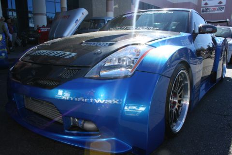 1998 Ford Crown Victoria - blue Nissan 350Z with a carbon hood, widebody fenders and front intercooler shown at a tire expo.