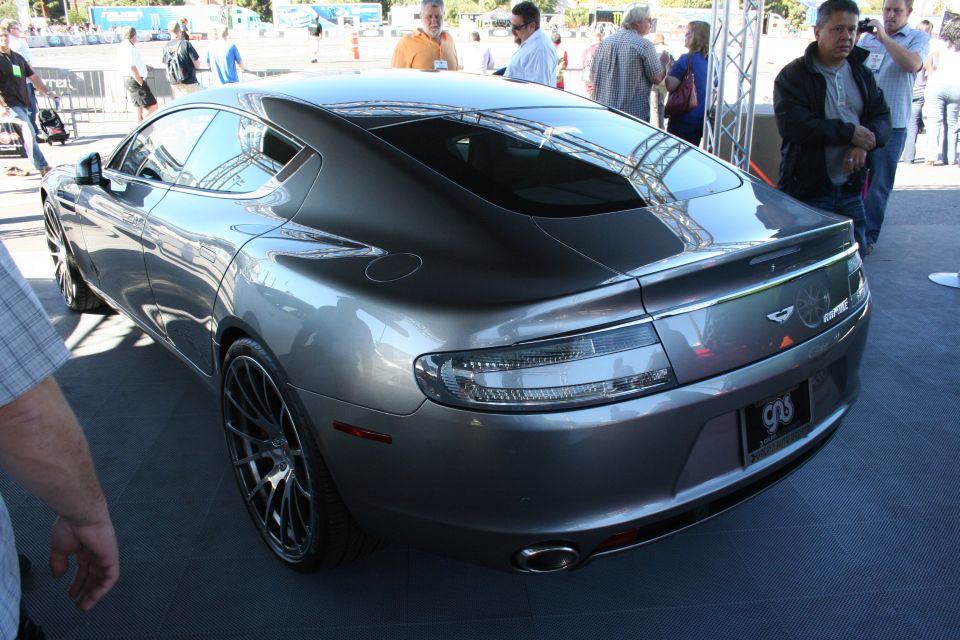 Rear quarter of gray Aston Martin Rapide sedan on a display platform