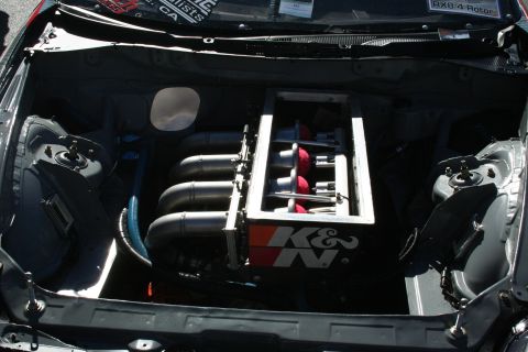 1998 Ford Crown Victoria - Open engine bay of a tuned car showing a row of individual throttle-body trumpets, red velocity stacks, and a K&N branded panel.