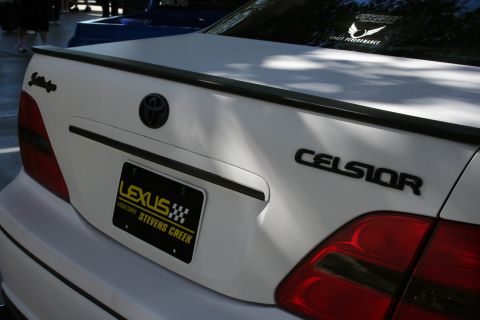 1998 Ford Crown Victoria - Close rear view of a white Toyota Celsior trunk showing the CELSIOR script badge, Toyota emblem, and a Lexus dealer plate frame.