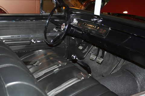 1998 Ford Crown Victoria - Interior of a classic car showing a black steering wheel, floor-mounted manual shifter, bench seat and chrome-trimmed dashboard gauges.