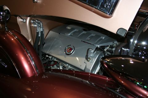 1998 Ford Crown Victoria - Close-up of a modern silver Cadillac-badged V8 engine swapped into the engine bay of a copper-painted vintage car.