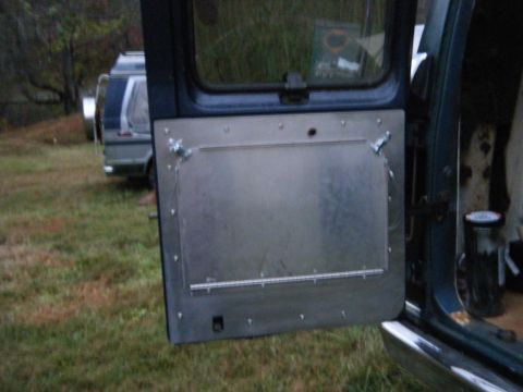 1981 Ford E350 - Van door interior with metal panel modification; another van is parked outside.