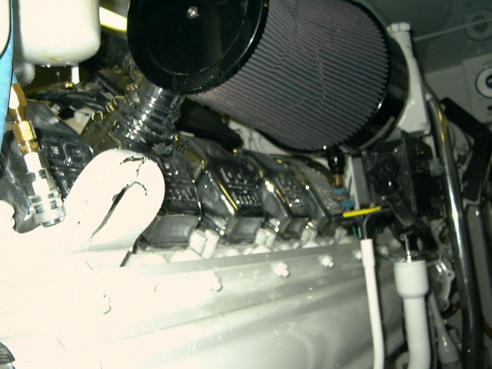 Engine close-up showing large black cone air filter on chrome intake with white-painted block and chrome covers