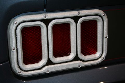 1998 Ford Crown Victoria - Close-up of a custom brushed-aluminum taillight housing with three red mesh-textured lens segments.