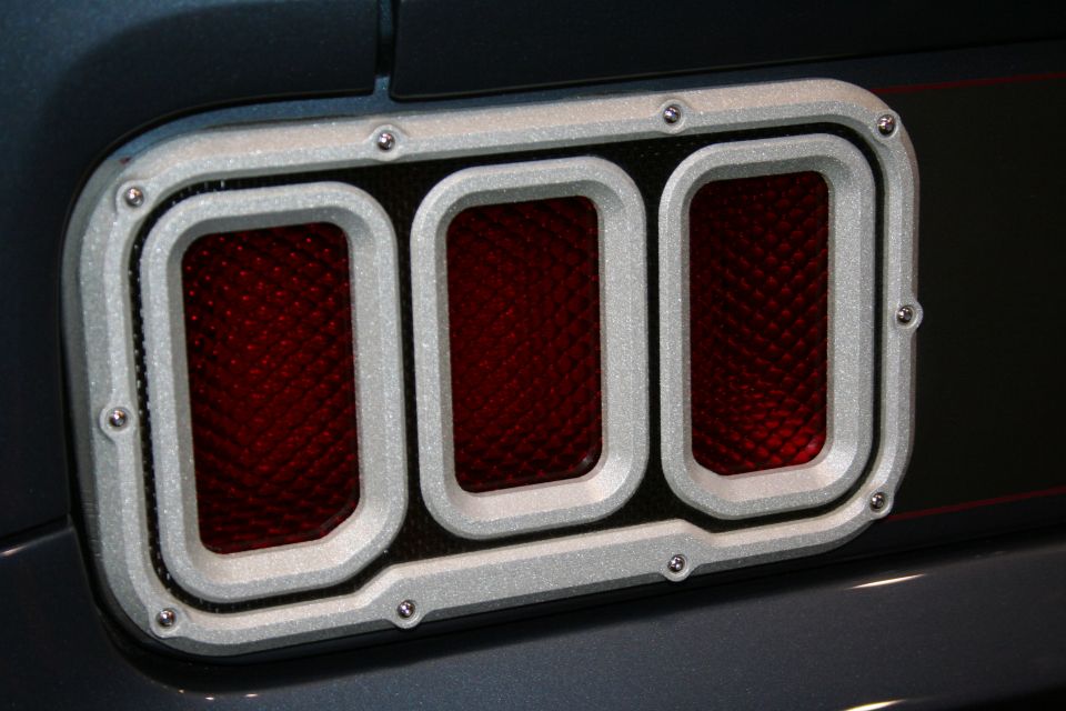 Close-up of brushed-metal three-segment taillight with red lenses