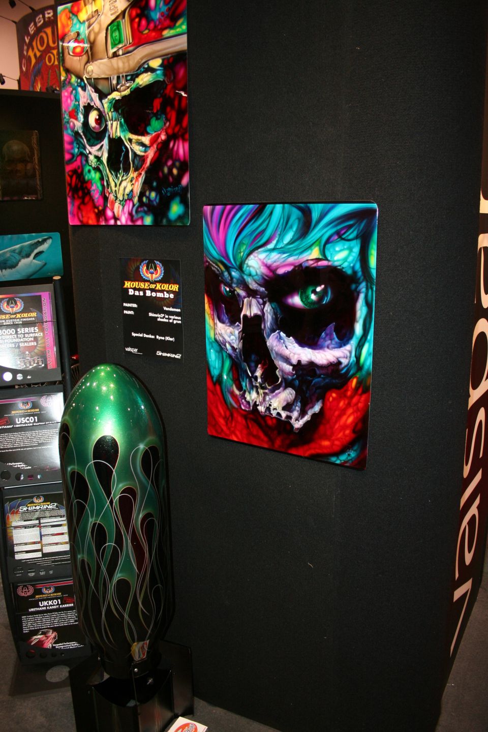 Airbrushed skull artwork panel on black booth wall with green board