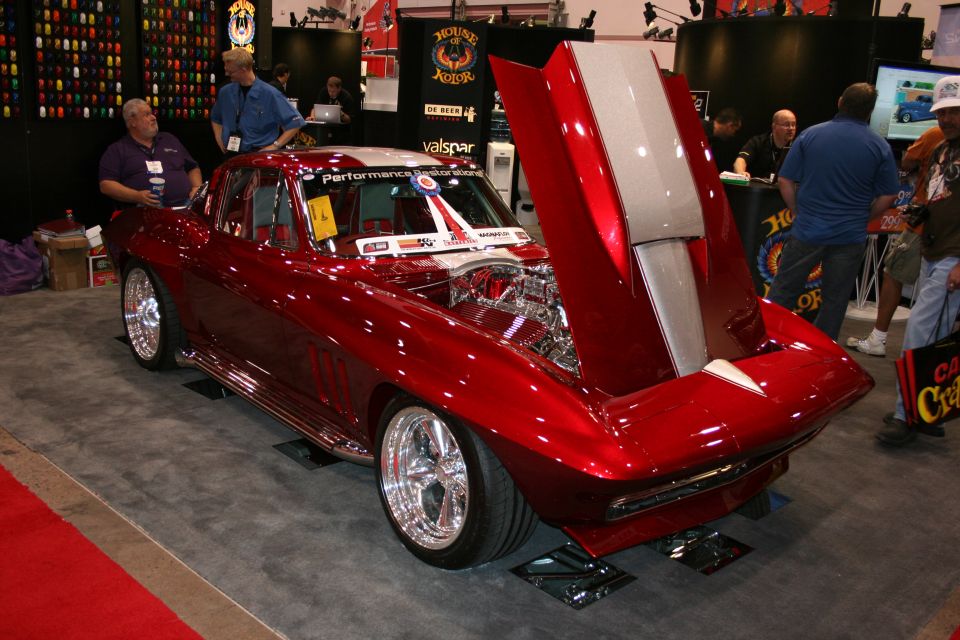 Candy-red custom sports coupe with raised front clip at a show