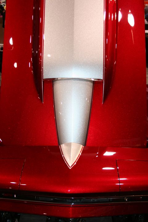1998 Ford Crown Victoria - Close-up of a candy-red custom car hood featuring a metallic silver pointed center stinger stripe.
