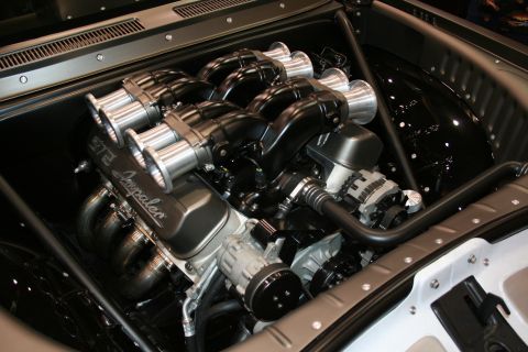 1998 Ford Crown Victoria - engine bay fitted with twin banks of polished individual-runner velocity stacks over a black engine, with Imperial script on the manifold.