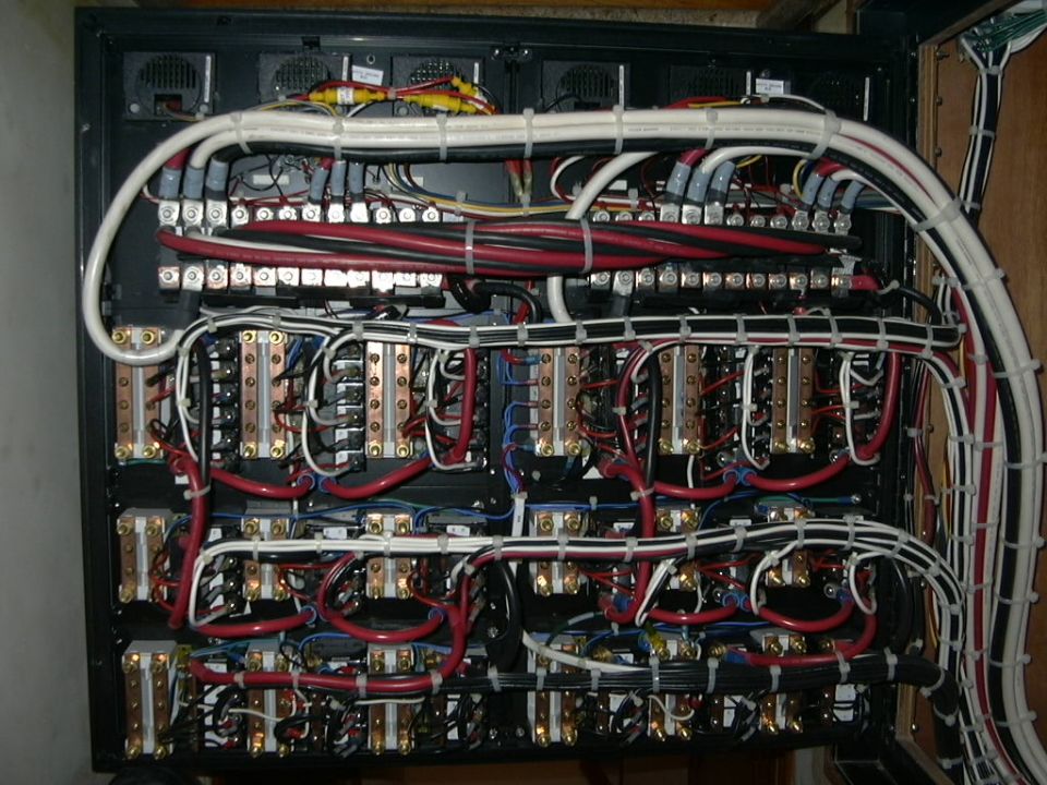 Industrial electrical relay panel with rows of breakers and red and white wiring
