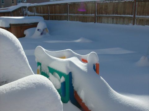 1995 Ford Bronco - A winter scene shows a snow-covered backyard with a children's playground slide.