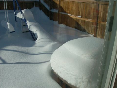 1995 Ford Bronco - A winter scene shows a backyard blanketed in snow, with a swing set and a partially obscured object.
