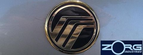 2000 Mercury Grand Marquis - Close-up of a Mercury emblem and a Zorg Industries logo on a metallic surface.