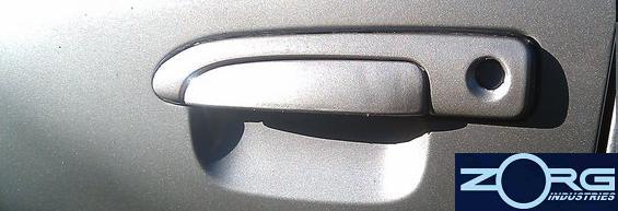 Gray door handle on a car door, with a Zorg Industries logo in the lower right corner