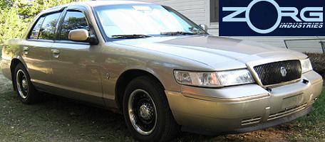 2000 Mercury Grand Marquis - Gold 2000 Mercury Grand Marquis with black wheels and tinted windows.
