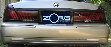 2000 Mercury Grand Marquis - The rear of a gold Mercury Grand Marquis is shown, tinted taillights and a Zorg Industries license plate frame.