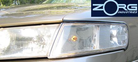 2000 Mercury Grand Marquis - Close-up of the headlight assembly on a gold 2000 Mercury Grand Marquis.