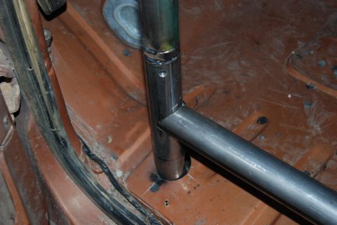 1982 Ford Bronco - Close-up of roll cage tubing being installed on a vehicle's floor pan.