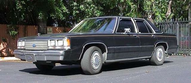Black 1980s Ford sedan, 3/4 front view