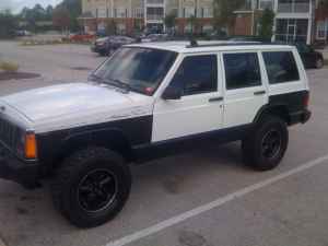 1992 Jeep Cherokee - A two-tone Jeep Cherokee is shown from the front three-quarter angle in a parking lot.