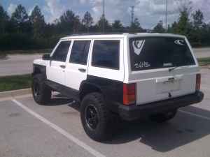 1992 Jeep Cherokee - A white Jeep Cherokee is parked in a lot, showing its rear and side profile.