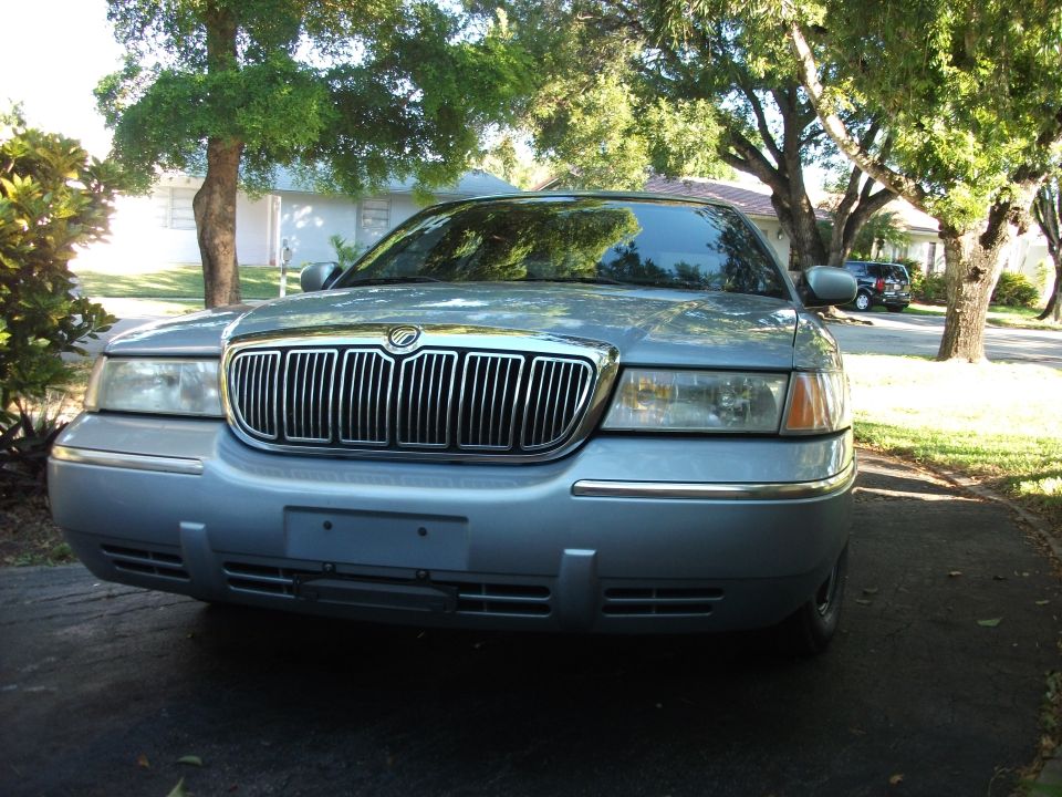 Front of light blue Mercury sedan with chrome grille in driveway