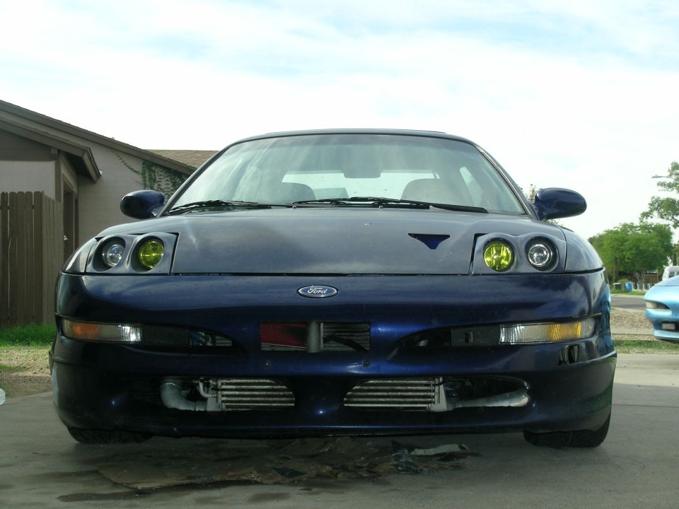 Front view of a blue Ford Probe with yellow headlights and visible intercoolers