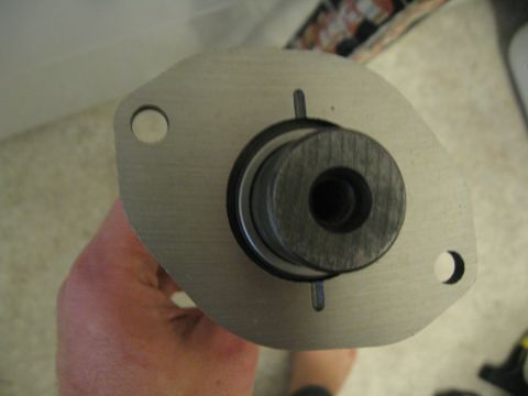 1981 Ford Bronco - A camshaft timing gear is held up for inspection, showing its metallic construction and central bore.