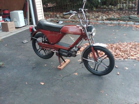1981 Garelli Rally Sport - A red Garelli moped is parked on a kickstand in a driveway, with a garage in the background.